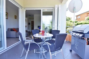 An outdoor patio with a grill, dining table, and chairs. - Equipped Flat Just a Short Walk From the Beach (Novigrad)