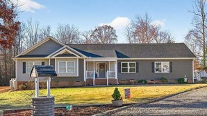A single-story house with a front porch, a small front yard, and a gravel driveway. - Olivet Oasis - saltwater pool, hot tub, pond, walking trails, game room (New Kent)