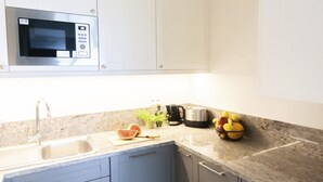 A kitchen with a microwave, sink, cabinets, countertop, and a bowl of fruit. - Spacious Comfy Apartment for 5 Dziwnow (Dziwnów)
