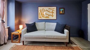 A room with a striped sofa, a rug, a lamp, and two artworks on the wall. - Host & Stay | The Apartment, Mulgrave House (Hinderwell)