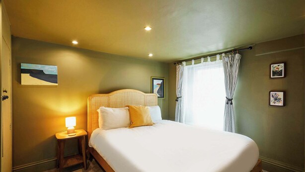 A bedroom with a large bed, a nightstand, a lamp, and a window with curtains. - Host & Stay | The Apartment, Mulgrave House (Hinderwell)