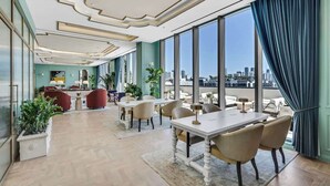 A spacious dining area with a city view, large windows, and modern decor. - Bright Open Wynwood 1BR · Balcony + Rooftop Pool (Miami)