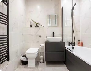 Een haardroger, handdoeken, zeep, toiletpapier