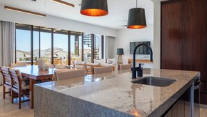 Una cocina moderna con encimera de granito, pileta integrada e iluminación colgante.