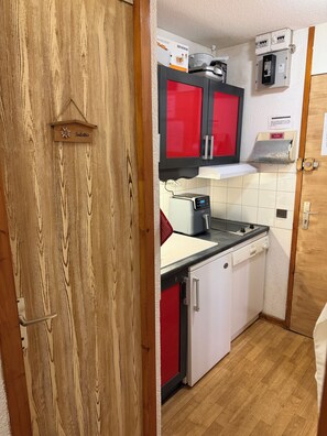 A compact kitchen with a red and white color scheme, featuring a sink, a dishwasher, and a stove. - Apartment for 4 People in Valmorel (Les Avanchers-Valmorel)