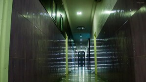 Un pasillo con paredes reflectantes y una lámpara central.