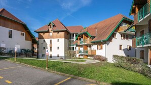 Eine Reihe traditioneller Chalets mit Holzhäusern und Satteldächern, die einen Innenhof bilden.