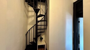 Una escalera de caracol con pared blanca y suelo de madera.