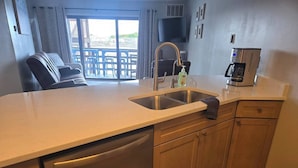 A kitchen with a dishwasher, sink, and coffee maker. - Recently renovated lake View Condo with balcony (Port Clinton)