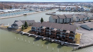 A waterfront property with multiple buildings, a dock, and a marina. - Recently renovated lake View Condo with balcony (Port Clinton)