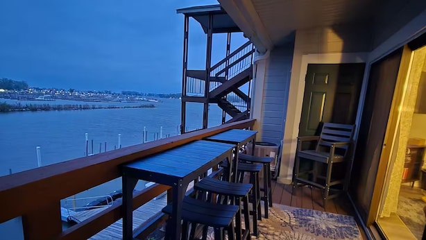 A balcony with a view of the water, a wooden deck, and a patterned rug. - Recently renovated lake View Condo with balcony (Port Clinton)