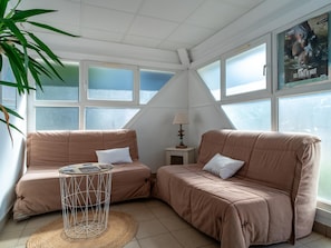 A room with two sofas, a small table, a lamp, and a poster on the wall. - Duplex, 200m to Falaise Beach (Guidel)