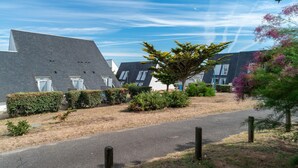 A residential area with modern houses, a paved road, and a variety of trees and shrubs. - Retreat With Heated Pool & Coast (Guidel)