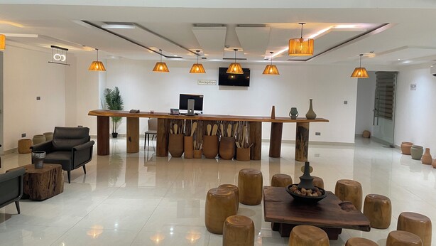 A reception area with a wooden reception desk, a television, and a sign labeled 'Reception'.
