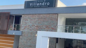 A modern building with a sign reading 'The Army @ Villandro Hotel, Restaurant, Conferences.'