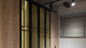 Una habitación con paneles de madera, una puerta corredera con iluminación y un aplique instalado en el techo.