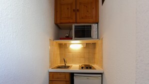 Eine kleine Küche mit Mikrowelle, Spüle und Geschirrspüler.