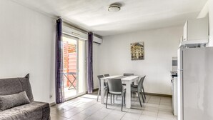 Un appartement moderne comprenant un coin repas, un canapé et un réfrigérateur.
