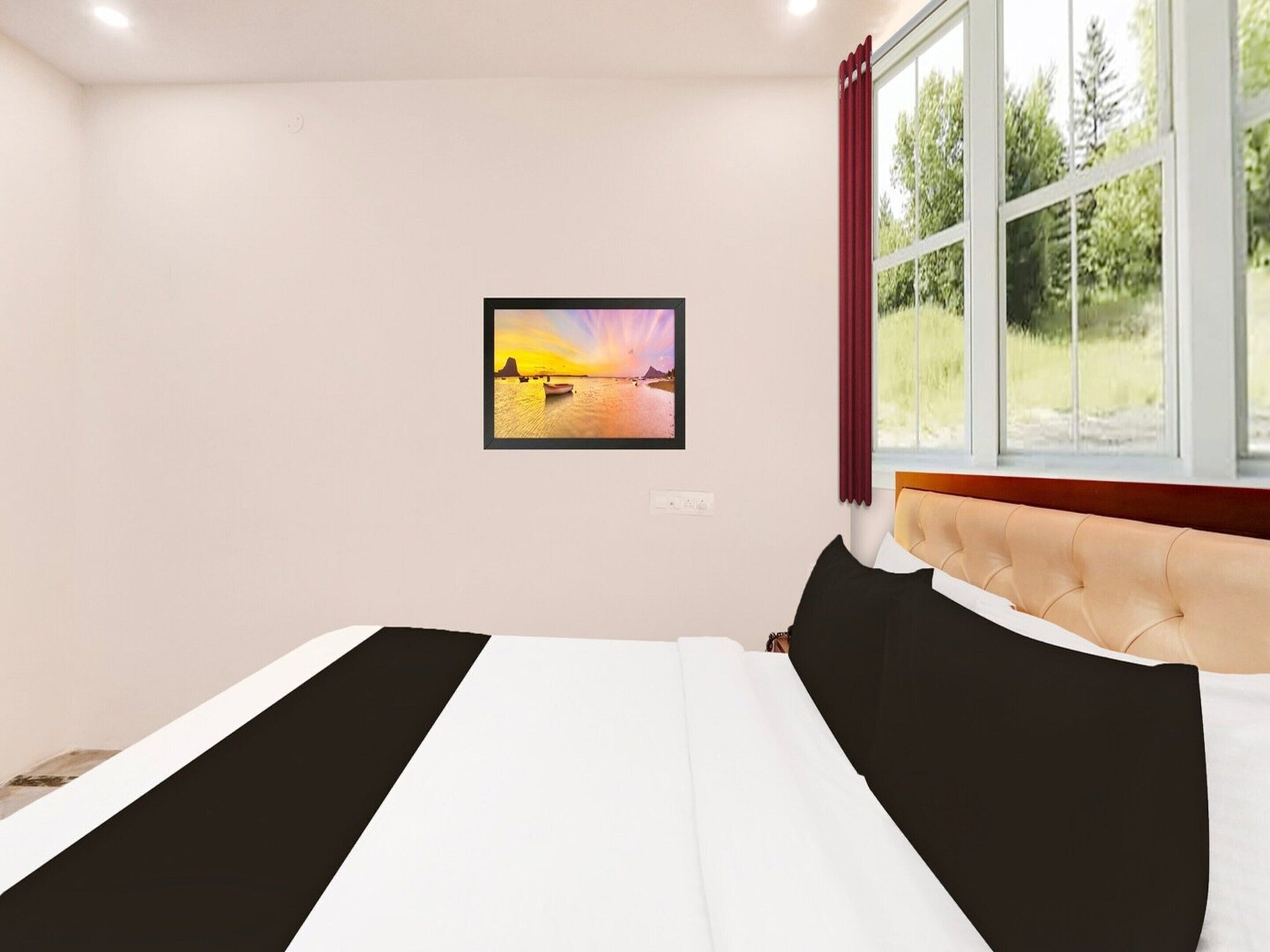 A bedroom with a bed, a window with curtains, a wall-mounted picture, and a view of greenery outside.