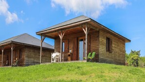 A wooden cabin with a porch, a table, and two chairs. - 6-person Wooden Chalet in Correze (Meyrignac-l'Eglise)