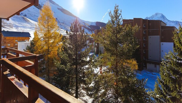 A hotel with a wooden balcony overlooking a snowy mountain landscape. - Studio in Les Deux Alpes With Balcony (Les Deux Alpes)