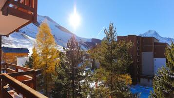 A hotel with a wooden balcony overlooking a snowy mountain landscape.
