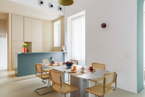 Una cocina moderna con comedor, que cuenta con una mesa grande, sillas y una isla de cocina.
