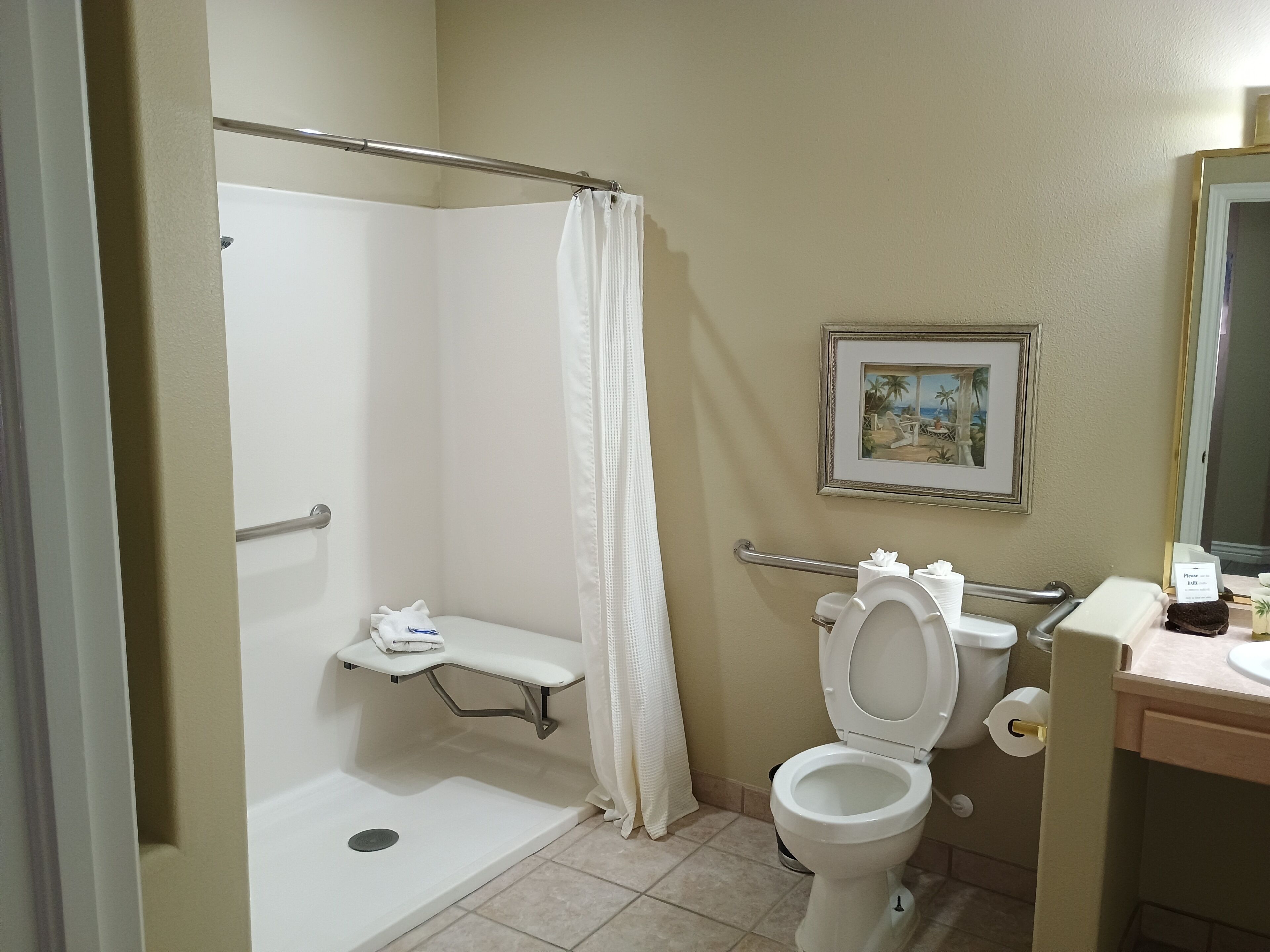 A bathroom with a shower, toilet, and sink.