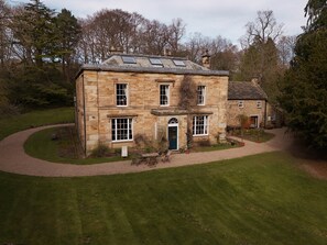 A stone building with a central entrance, multiple windows, and a surrounding lawn. - The Hall at Burnhopeside Hall Estate (Lanchester)
