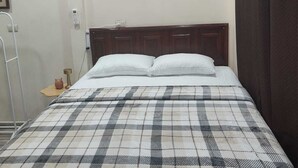 A room with a bed, a wooden headboard, a bedside table, a telephone, and a curtain. - WLC Stay (Ayutuxtepeque)
