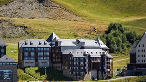 Un hotel moderno con diversi piani, ampie finestre e un ingresso ben visibile.