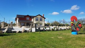 Ein Haus mit rotem Dach, Steinmauer und Rasenfläche.