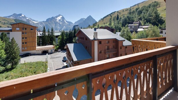 A mountain view with buildings, a wooden fence, and a clear sky. - Bright Apartment Close to Ski-slopes (Les Deux Alpes)