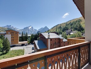 Blick auf Berge, Gebäude, einen Holenzaun und einen klaren Himmel.