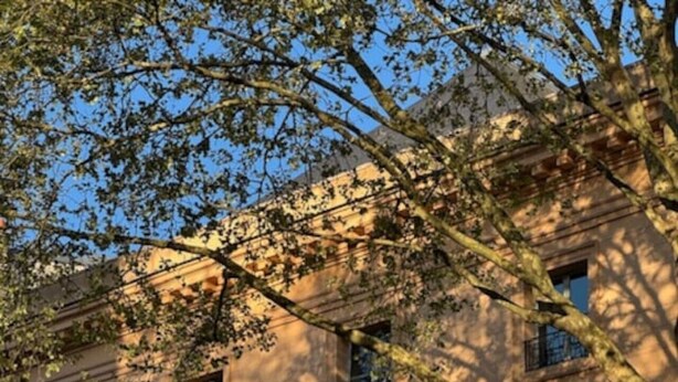 Un bâtiment de style classique, doté de nombreuses fenêtres et d’un balcon.