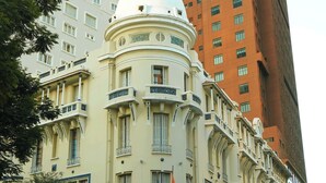 Een historisch gebouw met een opvallende koepel en een bord met de tekst 'SAGONTOURIS'.