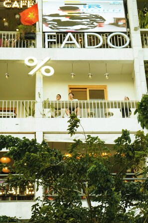 Un edificio de varios pisos con balcones, un gran símbolo de porcentaje y una bandera.