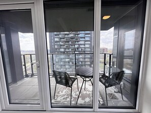 A balcony with a table and chairs, a view of a high-rise building, and a cityscape. - 2bedroom,2 bathroom apartment in the heart of Toronto (Toronto)