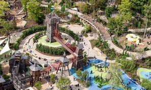 Ein Spielplatz mit Rutschen, Klettergerüsten und einem Rundgangweg.