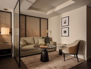 A modern living room with a sofa, armchair, coffee table, and a lamp.