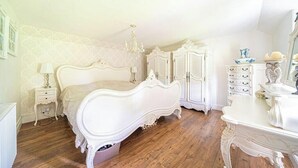 Une chambre à coucher avec un grand lit, une commode, une table de chevet et un miroir.