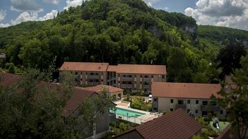 Zona residencial con varios edificios, piscina y montañas al fondo.