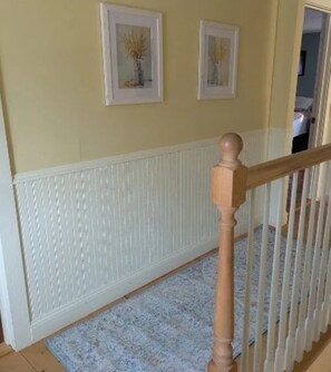 Eine Treppe mit weißer Geländer und einem blau gemusterten Teppich.