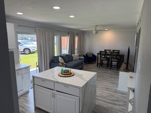 A modern living room with a sofa, dining table, and kitchen area. - Cozy updated 2-bedroom condo with AC in serene Destin. (Destin)