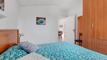 Ein Schlafzimmer mit einem Bett, einem Holzschrank und einem Bild an der Wand.