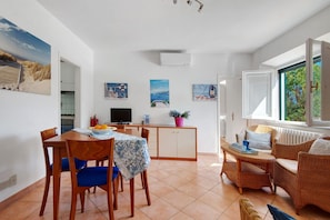 A compact living space with a dining area, kitchen, and seating area. - Apartment 'Agave' with Private Garden, Wi-Fi and Air Conditioning (Marina di Campo)