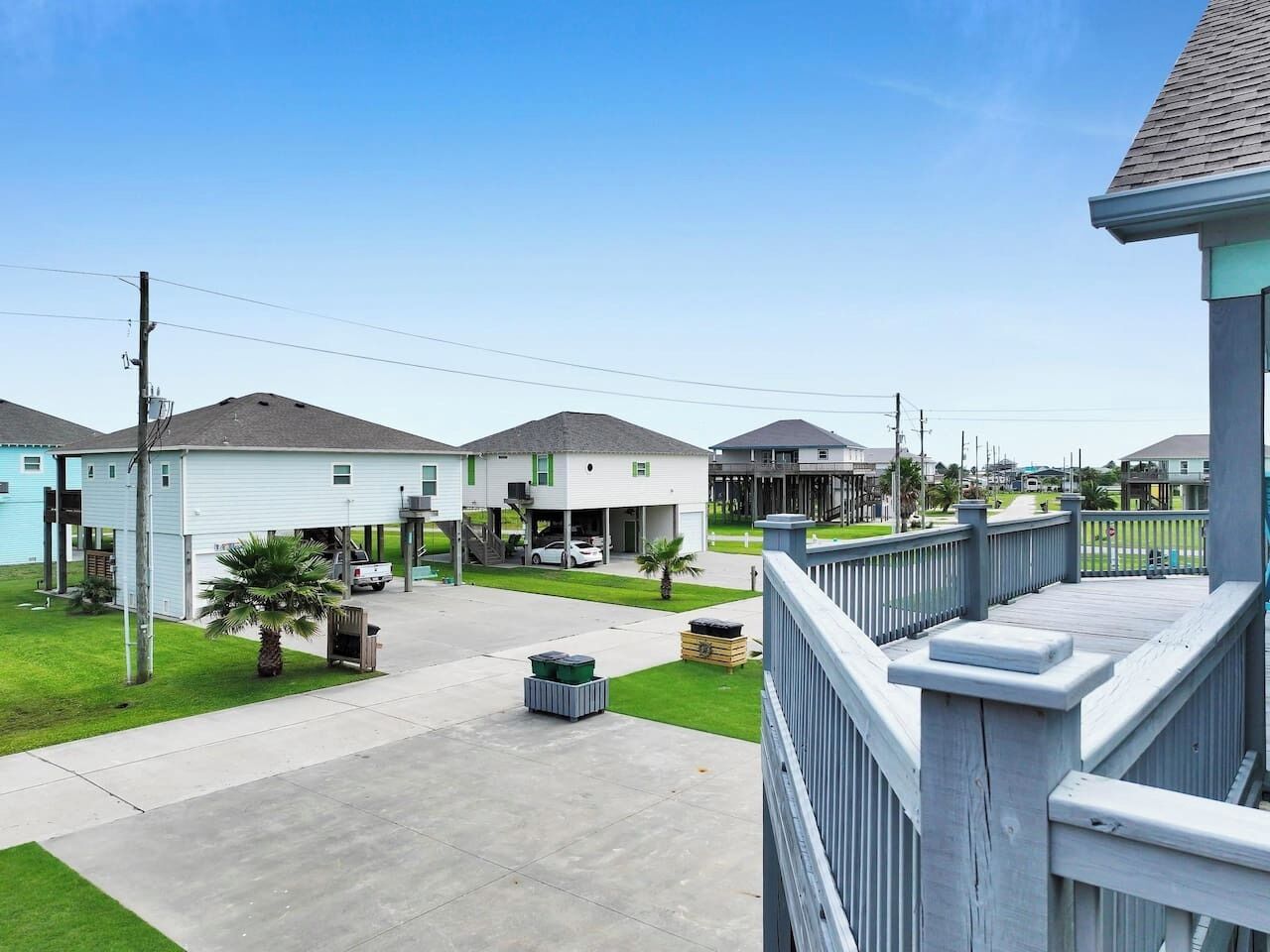 A residential area with houses, a driveway, and a wooden deck.