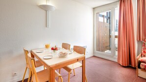 A dining area with a table, chairs, a basket of bread, a pitcher of orange juice, and a fruit bowl. - Quiet Alpine Stay Near Vercors (Villard-de-Lans)