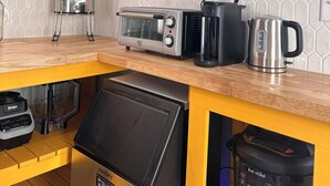 A kitchen with a microwave, toaster, kettle, and coffee maker on the counter.