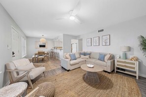 Ein modernes Wohnzimmer mit einer Couch, einem Couchtisch und einem Essbereich mit Stühlen.